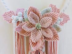 a close up of a flower made out of rope and beads on a white background