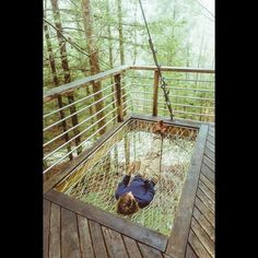 a man is laying in a hammock suspended by ropes on a wooden deck