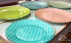 four plates sitting on top of a table with blue and green dots painted on them