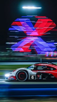 a racing car driving on a race track with motion blurry in the foreground