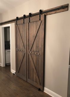 two wooden sliding doors in a room with hard wood flooring and white wall paint