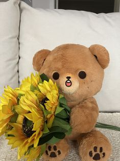 a teddy bear with sunflowers sitting on a couch