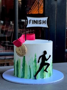 a cake with a running man on it and a finish sign painted on the side