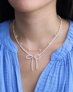 Embrace the bow-tiful blend of classic charm and contemporary design with the Pearl Bow Necklace from Poppy Rose. Playful and feminine, this necklace features white pearls and 14k gold-filled beads, tied together in a dainty bow. Whether styled with a casual sweater and jeans or a sparkly party dress, this necklace is sure to turn heads wherever you go. 14k Gold Filled White Pearl Length: Adjustable 14" - 16" Necklace With Pearls And Beads, White Necklace Beads, Necklace Beads Design, How To Make Bow With Beads, Bow Necklace Beads, Make Necklaces With Beads, Bow Beaded Bracelet, Bow Pearl Necklace, Beaded Bow Bracelet