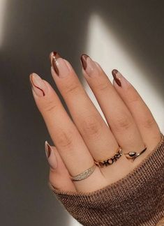 a woman's hand with some manicured nails and gold nail polish on it