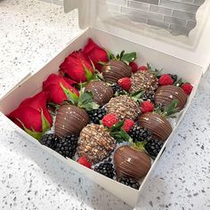 a box filled with chocolate covered strawberries and raspberries