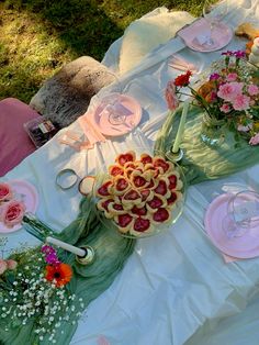 a table topped with plates and bowls filled with desserts on top of white cloth covered tables