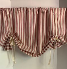 a red and white striped curtain hanging on the side of a wall