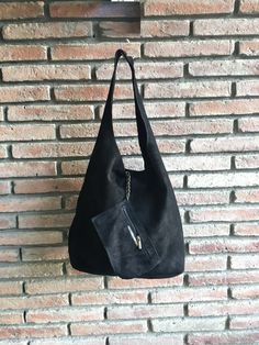 LARGE tote leather bag in dark BLACK. Natural genuine SUEDE leather. NOT LINED. We added a small leather zipper pouch for your mobile phone and/or cards or money. It ist attached to the inside of the bag by a metal chain. The bag is closed by a metal clip at the center. Width : 42cm - 16,5 in Height at the center: 34 cm - 13, 5 inc Total height : 65,5 cm - 26 inch This bag in different colors and other leather Bags by Good Times Barcelona: https://www.etsy.com/shop/goodtimesbarcelona?section_id= Suede Shoulder Bag With Textured Leather For Daily Use, Rectangular Suede Shoulder Bag With Textured Leather, Textured Suede Leather Shoulder Bag For Daily Use, Daily Use Suede Shoulder Bag With Textured Leather, Suede Hobo Tote Bag With Removable Pouch, Evening Suede Hobo Bag With Soft Leather, Suede Hobo Bag With Removable Pouch, Suede Hobo Shoulder Bag With Soft Leather, Soft Leather Suede Hobo Shoulder Bag