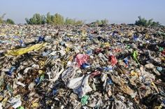 a large amount of trash is piled on top of each other in the middle of a field