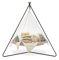 a white hammock hanging from the ceiling with pillows and blankets on it's sides