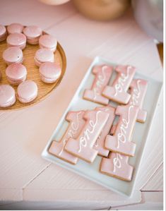 some cookies and marshmallows are on a plate next to a wooden tray