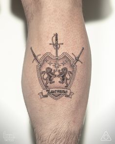 a man's leg with a tattoo on it and two swords in the middle