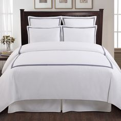 a bed with white sheets and black trims