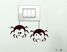 two spider wall decals hanging from a light switch