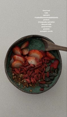 a bowl filled with strawberries, nuts and other things on top of a table