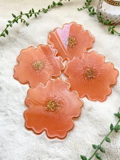 three orange flower shaped plates sitting on top of a white rug