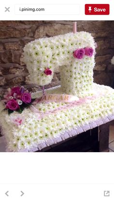 a cake made to look like a sewing machine with flowers on the front and side