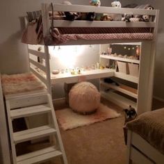 there is a bunk bed in the room with two ladders and a desk underneath it