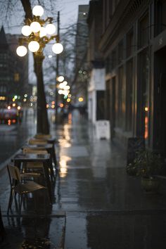 a row of benches sitting on the side of a street next to a lamp post