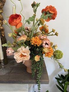 a vase filled with lots of flowers on top of a table next to a candle