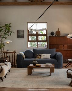 a living room filled with furniture and a large wooden table in front of a window