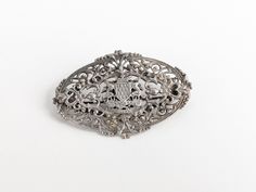 Showcase a touch of Gallic style flair with this elegant 'A Ma Vie' brooch, a patriotic emblem of French Brittany. Crafted in the 1800s during the Victorian era, this accessory is designed with an intricate silver filigree coat of arms, beautifully encapsulated within an oval crest shield. A stunning piece of historical jewellery, the brooch encapsulates Bretagne's rich cultural heritage. Fastens with a trombone 'push-pull' backing pin fastening, unbranded, no hallmarks (acid tested). A remarkab Ornate Oval Engraved Brooches, Victorian Oval Filigree Brooches, Oval Brooches With Intricate Design For Wedding, Oval Wedding Brooches With Intricate Design, Ornate Oval Filigree Brooches, French Brittany, Crest Shield, Victorian Jewellery, Old Stamps