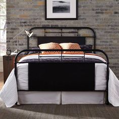 a black metal bed frame with two pillows