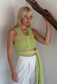 The Serendipity Knit Wrap Top features an empire waist with a cropped body and straps that can be wrapped front to back or back to front. This top can be wrapped several different ways. We have shown it in three different ways. Worn with the American Dream Trouser. Also comes in Lavender! Color: Celery Knit Fabrication Cropped Wrap Tie Straps Wear Front To Back Or Back To Front 60% Cotton/40% Acrylic Model Is 5'7", 32A Bust & Is Wearing Size Small/Medium Size Up For Larger Bust Size Chic Knit Halter Top For Beach, Fitted Knit Wrap Top, Trendy Knit Wrap Top, Chic Knit Cami Crop Top, Summer Wrap Top With Tie Back, Versatile Sleeveless Fitted Wrap Top, Versatile Fitted Sleeveless Wrap Top, Fitted Multi-way Top For Spring, Trendy Summer Wrap Top