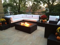 a fire pit sitting on top of a patio surrounded by furniture