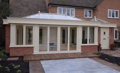 an orange brick house with white glass doors