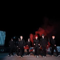 a group of men standing next to each other in front of a truck at night