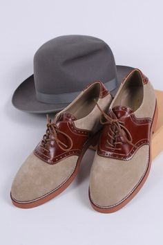 Casual men's two-tone 1950s-style oxford/saddle shoes with brogue pattern. These two-tone, 1950s-inspired, casual everyday oxfords feature an almond-shaped toe cap. The shoe is made of suede and features cognac brown full-grain leather with a brogue pattern on the backstay and around the vamp. The outsole is crafted from brown lightweight rubber with white stitching on the welt. These shoes have a casual, sporty, and authentic 50s look, pairing exceptionally well with jeans or wide trousers. The 1930s Shoes, Saddle Shoe, 1950s Shoes, 1920s Shoes, 1940s Shoes, Vintage Style Shoes, Saddle Shoes, Winter Fashion Boots, Wide Trousers