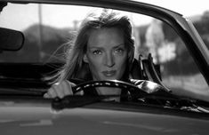 a woman sitting in the drivers seat of a car