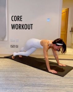 a woman in white is doing a yoga pose on a black mat with the words core workout above her