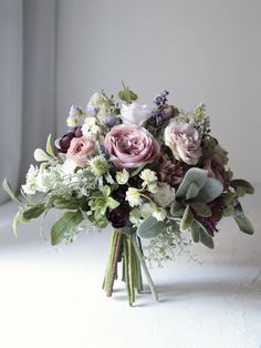 a bouquet of flowers sitting on top of a white table next to a window sill