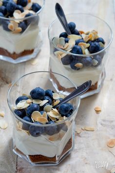 two desserts with blueberries, almonds and yogurt in small glass dishes