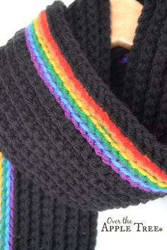 a black scarf with multicolored stripes on the ends and a wooden hanger