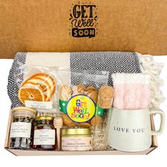 an open gift box containing bread, jams and other food items with the words get well soon written on it