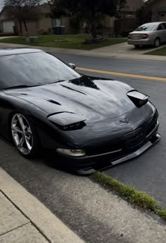 the black sports car is parked on the side of the road