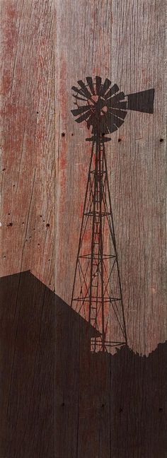 a windmill painted on the side of a wooden fence