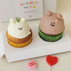 two cupcakes with frosting on them are sitting next to each other in front of a card that says my dessert matee