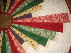 a quilted table topper with red, green and yellow strips on it's center