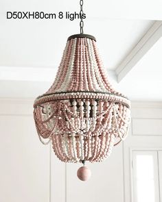 pink beaded chandelier hanging from the ceiling in a room with white walls