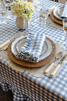 the table is set with blue and white checkered napkins, silverware, and flowers