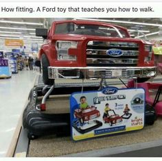 a red truck is sitting on top of a display in a store and it's saying, how fitting a ford toy that teaches you how to walk