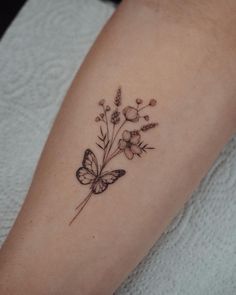 a butterfly and flower tattoo on the arm