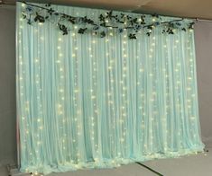 the curtain is decorated with flowers and lights on it's sides, along with greenery