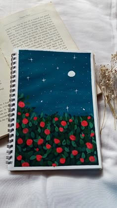 an open book on a bed with flowers and stars in the sky next to it