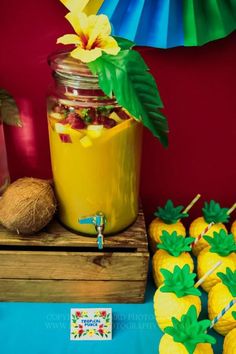 a table topped with pineapples and jars filled with fruit